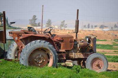 Tractor scrap on field against clear sky