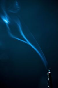 Close-up of burning incense against sky at night