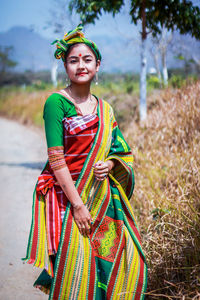 Portrait of young woman in traditional clothes standing outdoors