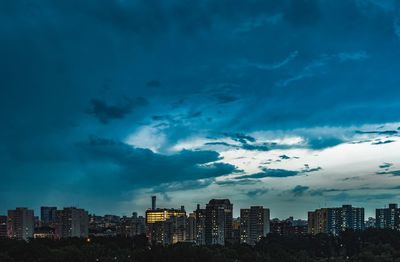 Buildings in city against sky at dusk