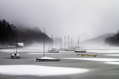 Boats in lake against sky