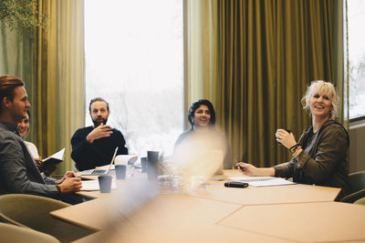 Business colleagues discussing at conference table in board room