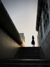Woman standing outside building on steps