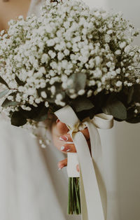 Portrait of an unrecognizable caucasian bride with a bouquet of boutonnier