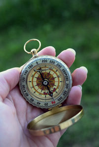 Cropped hand of woman holding navigational compass