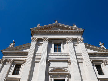 Low angle view of historic building against blue sky