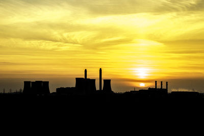 Silhouette buildings against sky during sunset