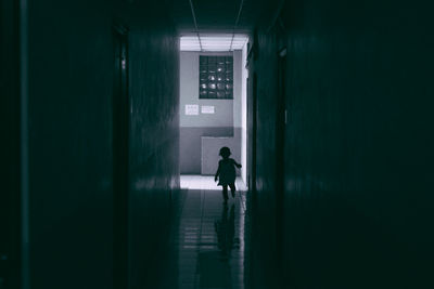 Silhouette man walking in corridor of building