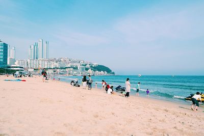 People at beach against sky