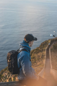 Student wearing a jacket enjoys the view from cristo rei, camara de lomos, madeira, portugal