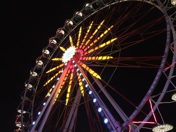 Low angle view of illuminated ferris wheel against sky at night