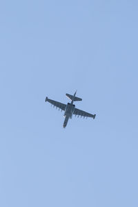 Low angle view of airplane against clear blue sky