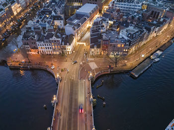 High angle view of illuminated city by river at night in amsterdam