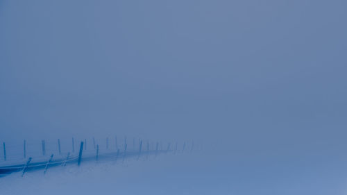 Scenic view of snow covered landscape against clear blue sky