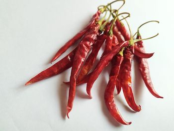 High angle view of red chili peppers on white background