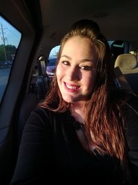 Portrait of smiling woman sitting in car
