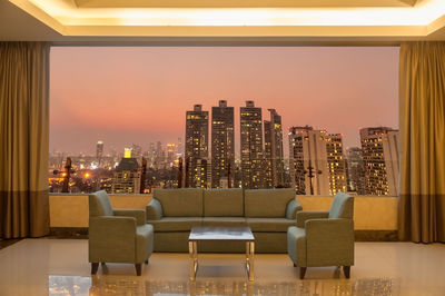 Illuminated modern buildings against sky in city