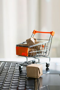 Close-up of small shopping cart on laptop