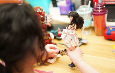 High angle view of girl playing with toy doll at home