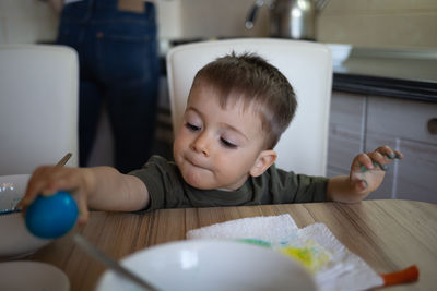 Portrait of cute boy eating food at home