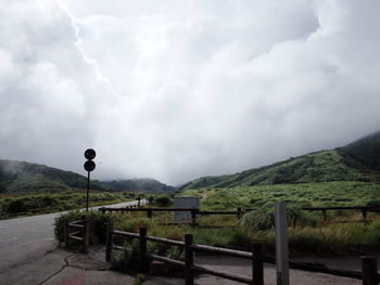 Road by mountains against sky