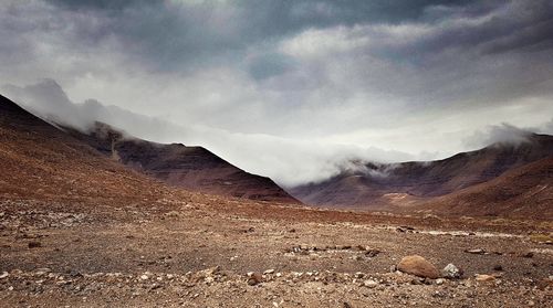 Idyllic view of mountains against cloudy sky