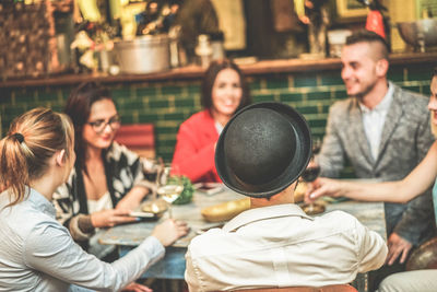 Smiling friends sitting in restaurant