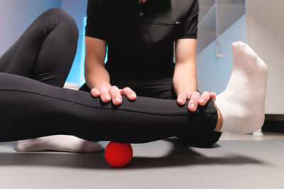 Myofascial release. a male physiotherapist puts a ball to rehabilitate the leg muscles of a client