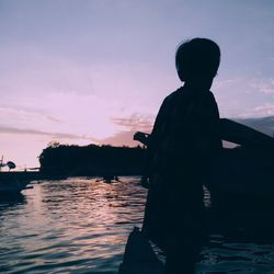 Silhouette man standing against sky during sunset