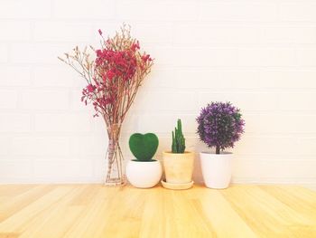 Flower vase on table against wall