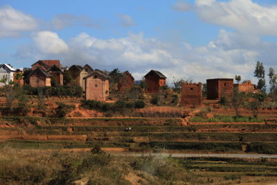 Houses on field against sky