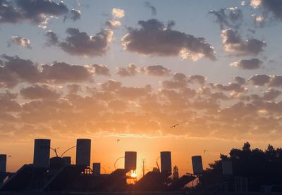 Silhouette buildings against sky during sunset