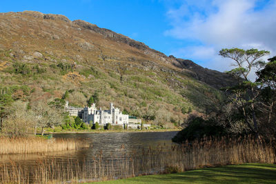 Scenic view of lake by buildings against sky
