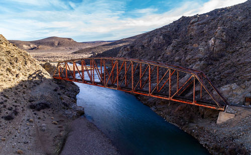 Bridge over mountain against sky