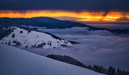 Scenic view of snowcapped mountains against sky during sunset