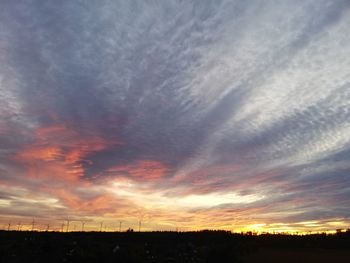 Silhouette landscape against dramatic sky during sunset