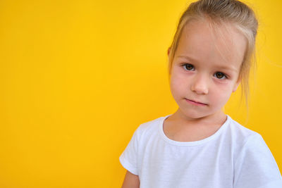 Close-up of cute girl against yellow background