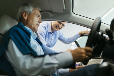 Salesman advising customer in car dealership