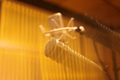 Close-up of microphones in recording studio seen through glass