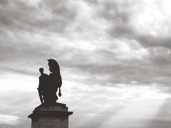 Low angle view of statue against cloudy sky