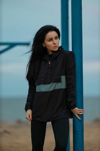 Portrait of young woman standing at beach