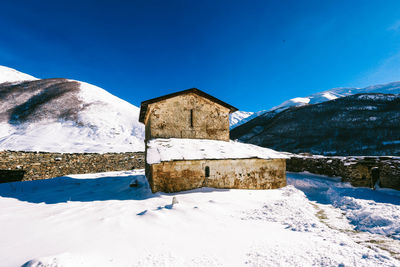 Snow covered mountain against blue sky monastery around the mountains, snow-capped mountains