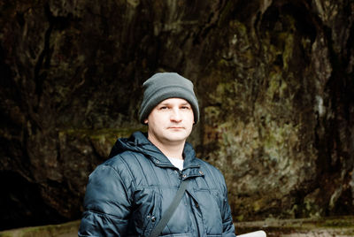 Portrait of man standing against cave