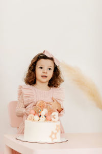 Portrait of a charming little girl with a cake during a birthday celebration