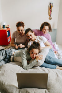 Female friends watching movie together on laptop at home