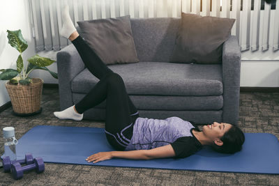 Woman lying on sofa at home