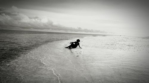 Boy playing in water against sky