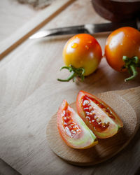 High angle view of tomatoes on cutting board at table