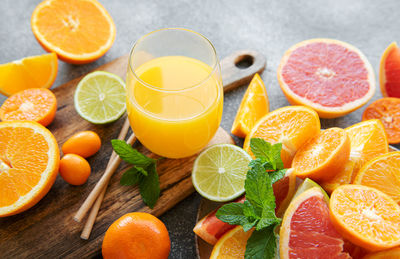 Glass of juice and fresh citrus fruits