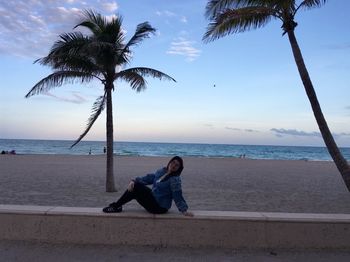 Full length of woman sitting on beach